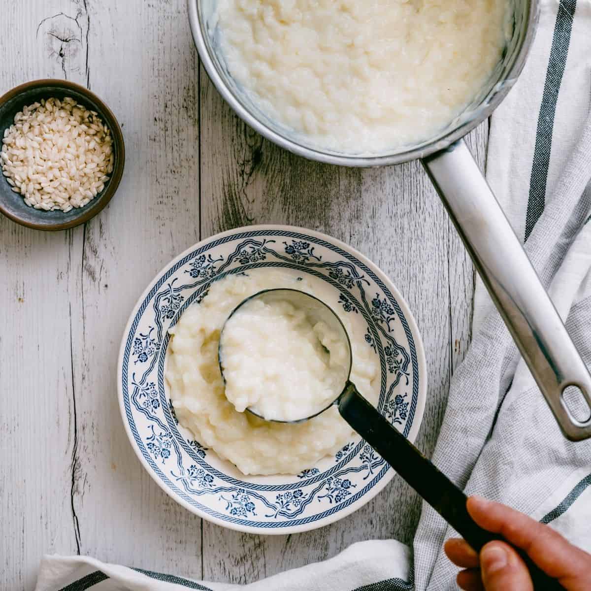 scooping Greek rice pudding into a bowl.