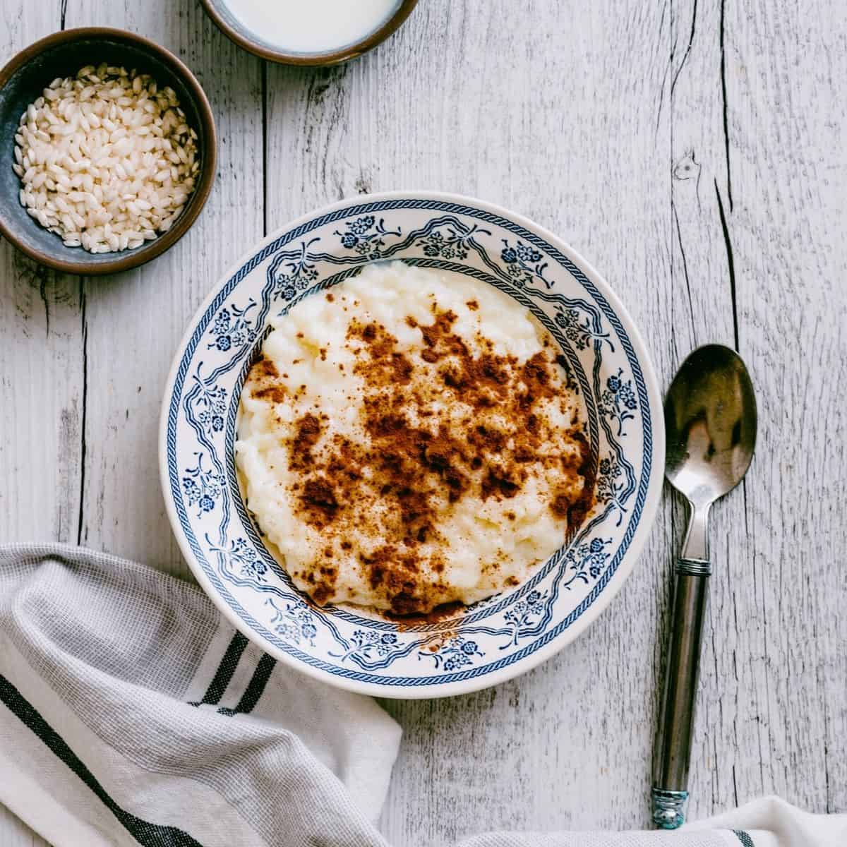 Greek rice pudding served in a bowl and topped with ground cinnamon.