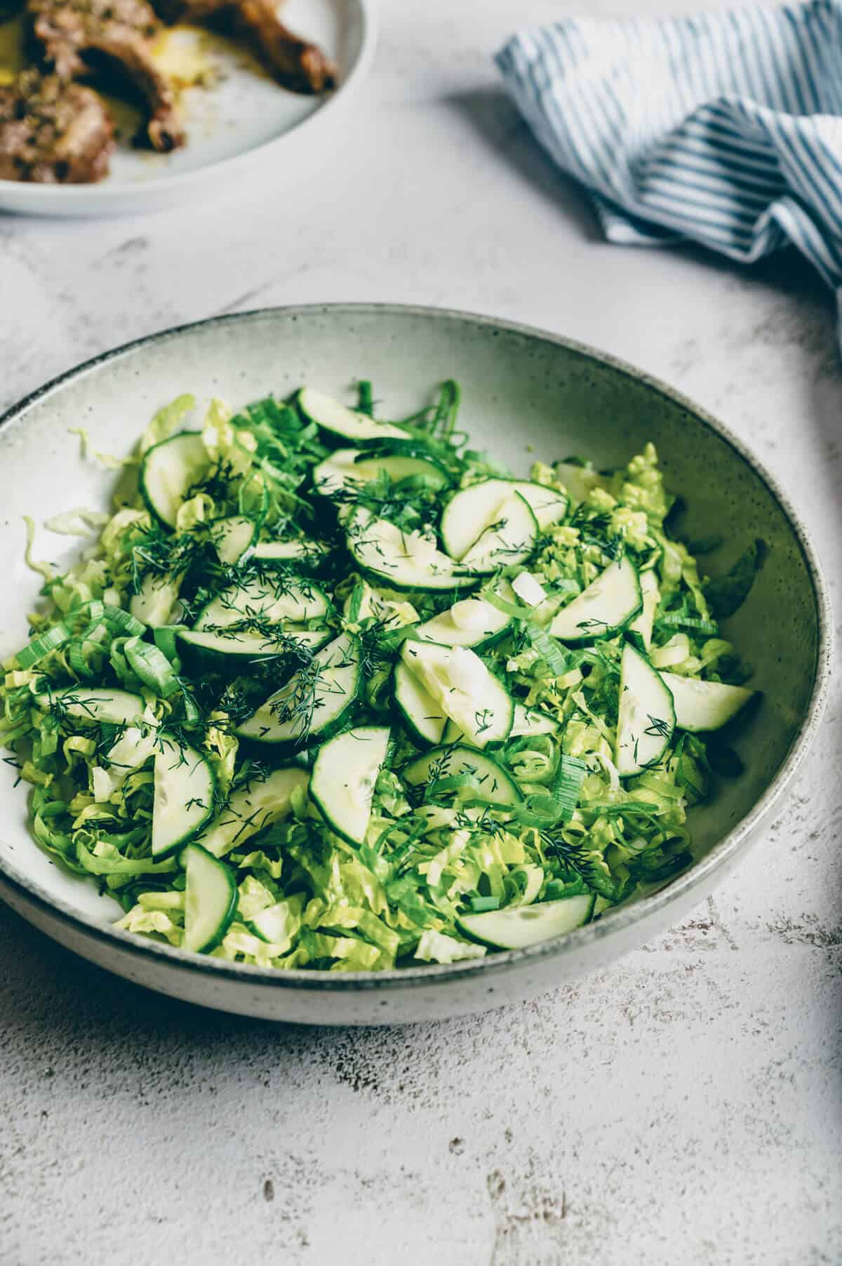 a large bowl of Greek lettuce salad on a rustic table.