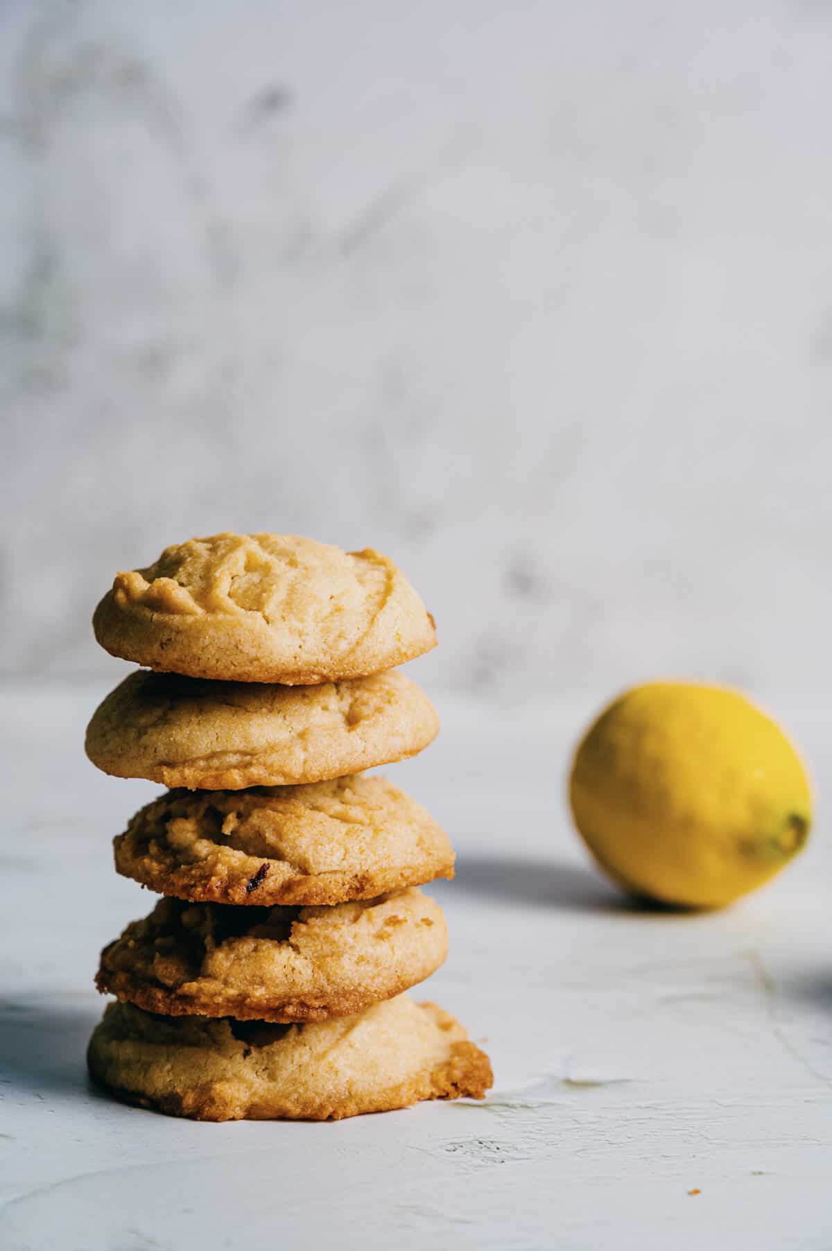 a stack of cookies with a lemon in the background.
