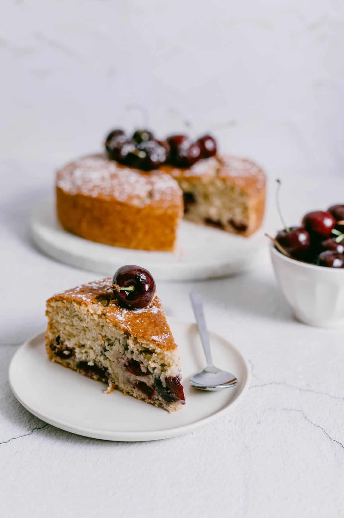 a slice of cherry and coconut cake on a white plate.
