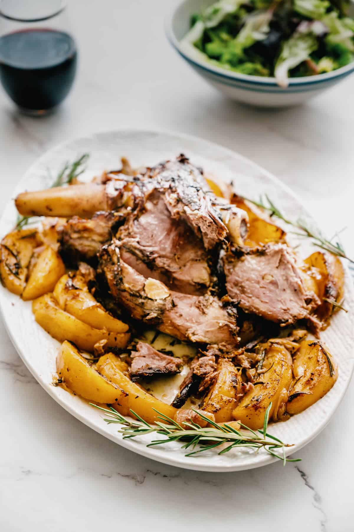 a platter with carved lamb and roast potatoes.