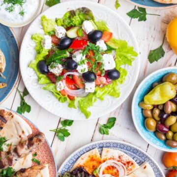 a white wooden table filled with traditional Greek recipes.