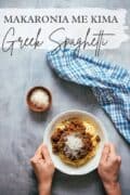 a Pinterest graphic showing 2 hands holding a bowl of Greek spaghetti.