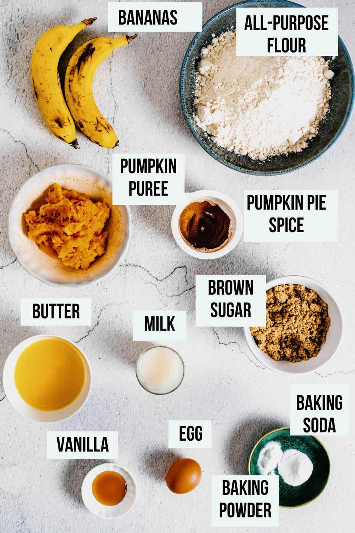 ingredients for pumpkin banana muffins on a white surface.
