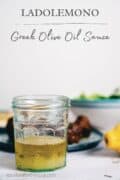 a Pinterest graphic showing a jar of Greek olive oil sauce on a table.