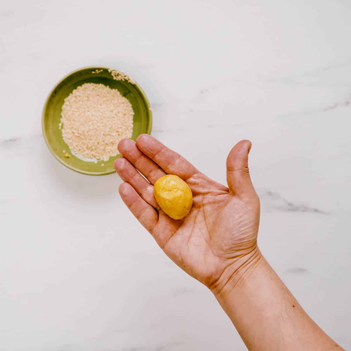 olive oil cookie dough ball in a hand.