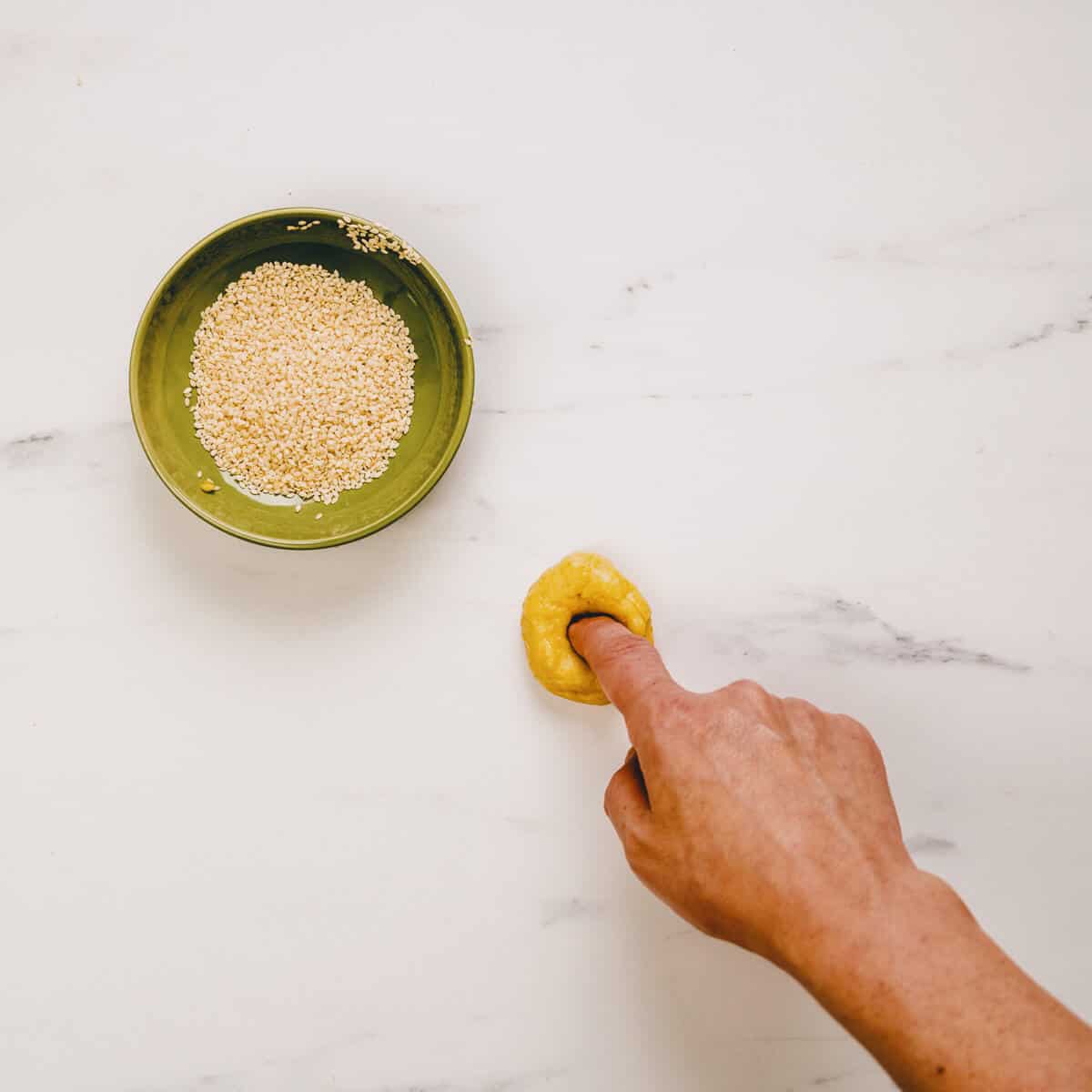 forming greek olive oil cookies on a marble surface.