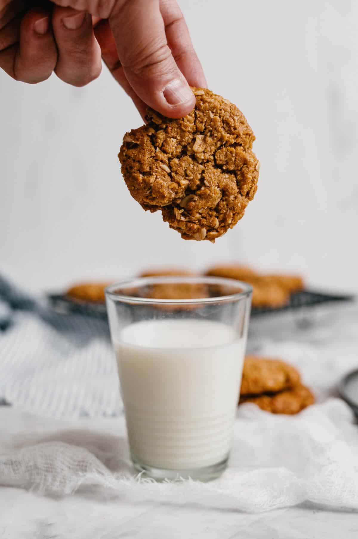 dipping an Anzac biscuit into a glass of milk.