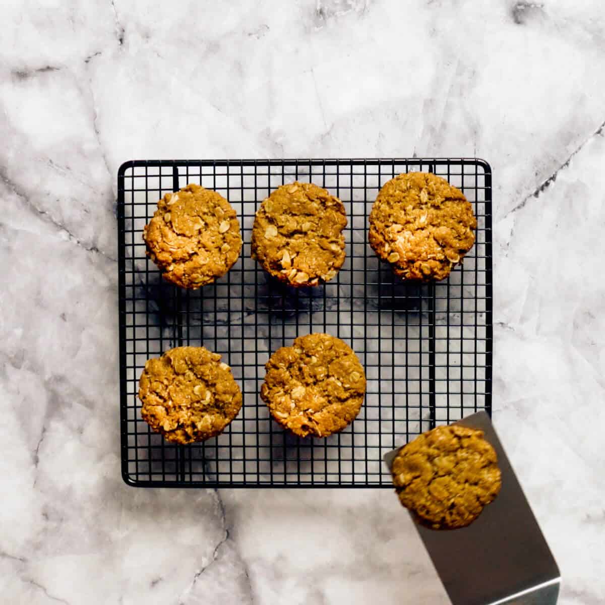 placing Anzac biscuits on a wire rack to cool.