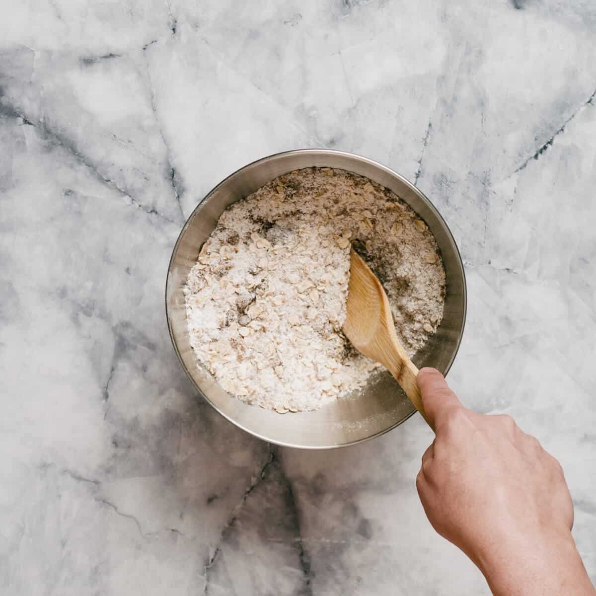 combining dry ingredients to make Anzac biscuits.