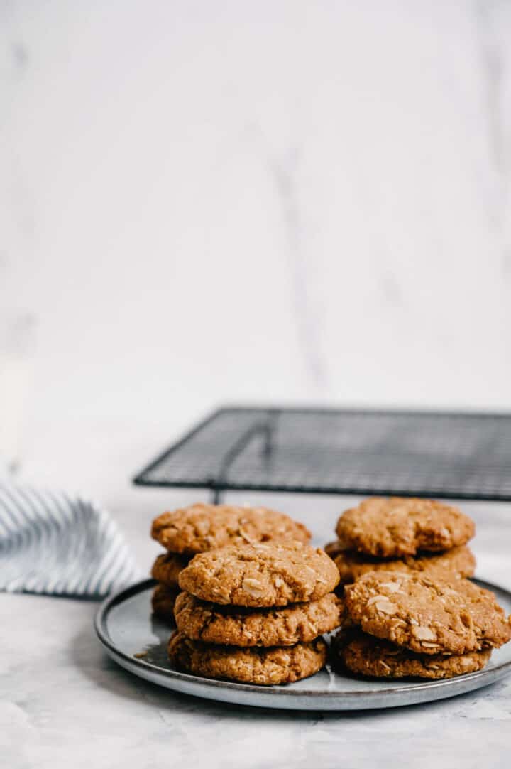 a pile of Anzac biscuits on a grey plate.