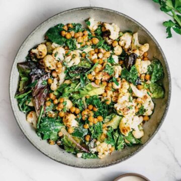 roasted cauliflower chickpea salad served in a bowl on a marble table.