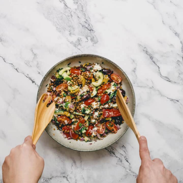 tossing a salad in a large bowl.