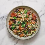 A greek lentil salad presented in a large bowl.