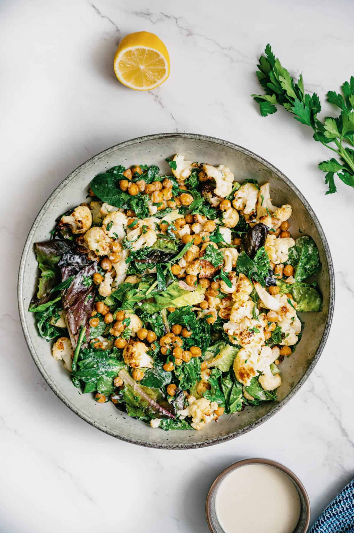 roasted cauliflower chickpea salad served in a bowl on a marble table.