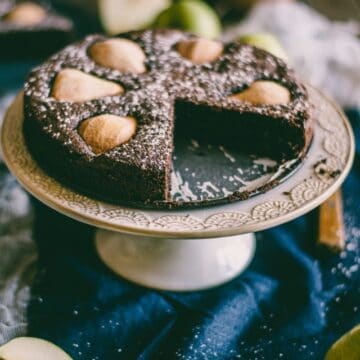 a chocolate and pear cake on a cake stand.