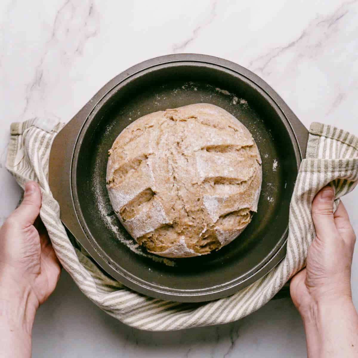 a baked loaf of Greek bread in a Dutch oven.