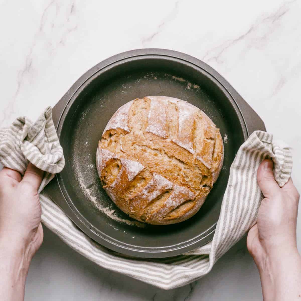 a baked loaf of Greek bread in a Dutch oven.