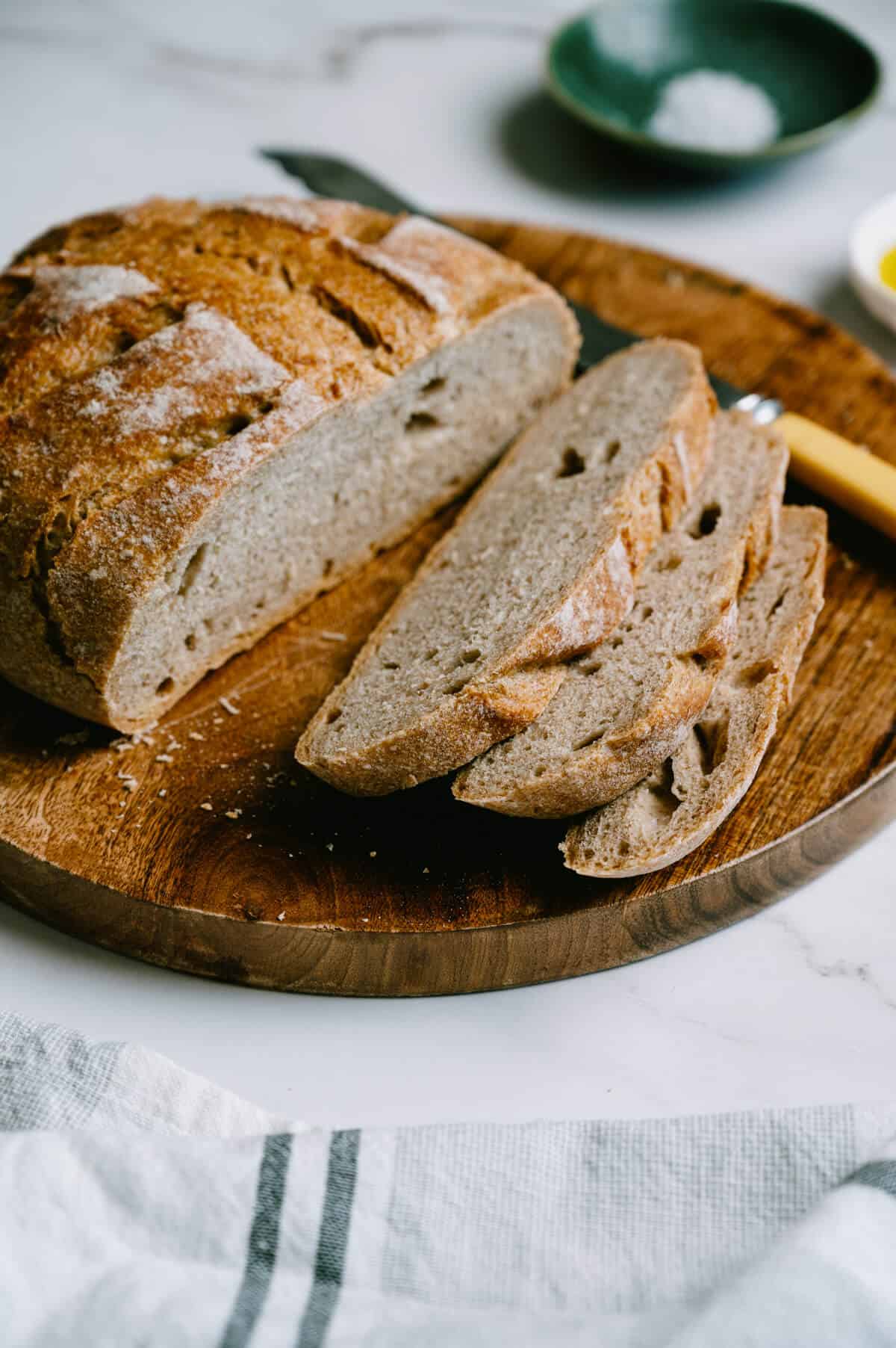 sliced fresh bread on a wooden board.