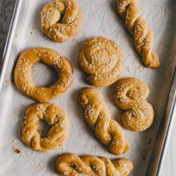 freshly baked koulourakia or Greek Easter cookies on a lined baking tray.