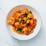 braised greek cauliflower served in a large white bowl.