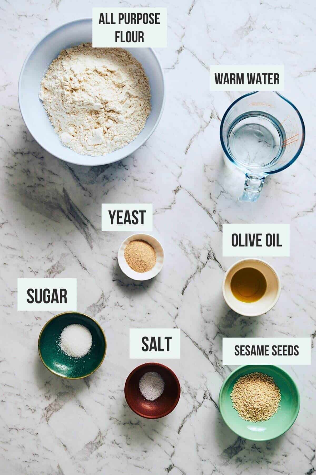the ingredients to make lagana bread on a white marble table.