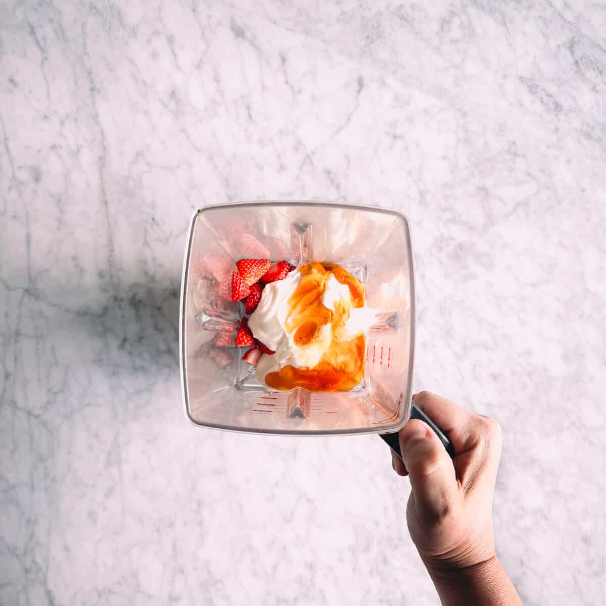 ingredients to make strawberry popsicles in a blender.