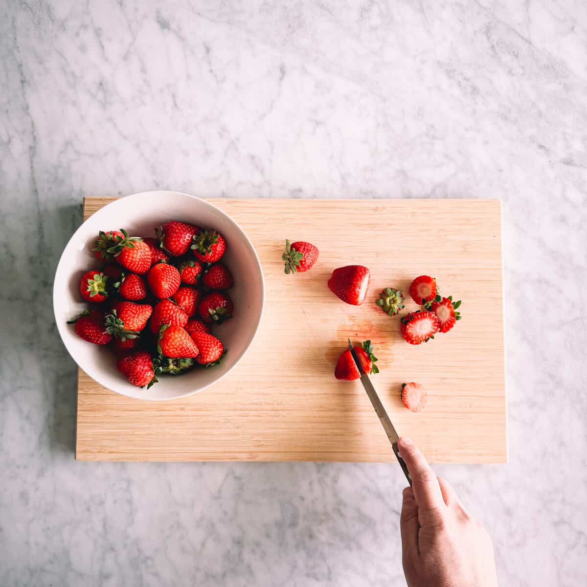 chopping strawberries on a chopping board.