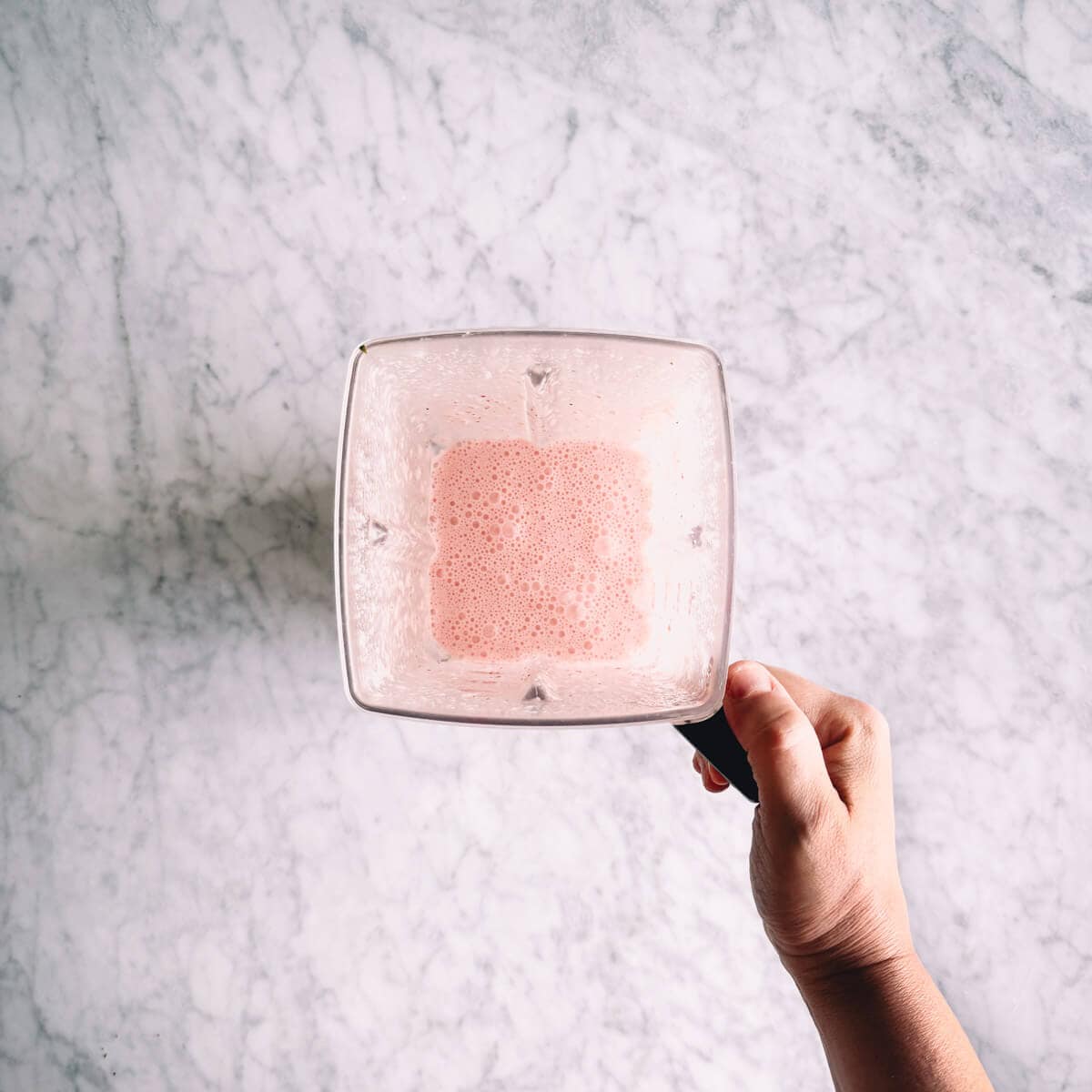 strawberry popsicle mixture blended in a blender.