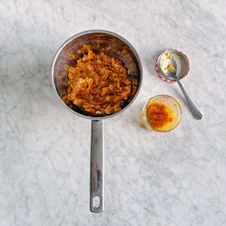 cooked mandarin jam spooned into a jar.
