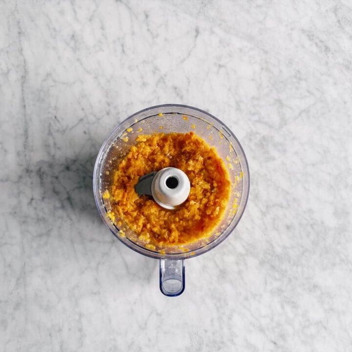 a food processor filled with mixed mandarins ready to make jam.