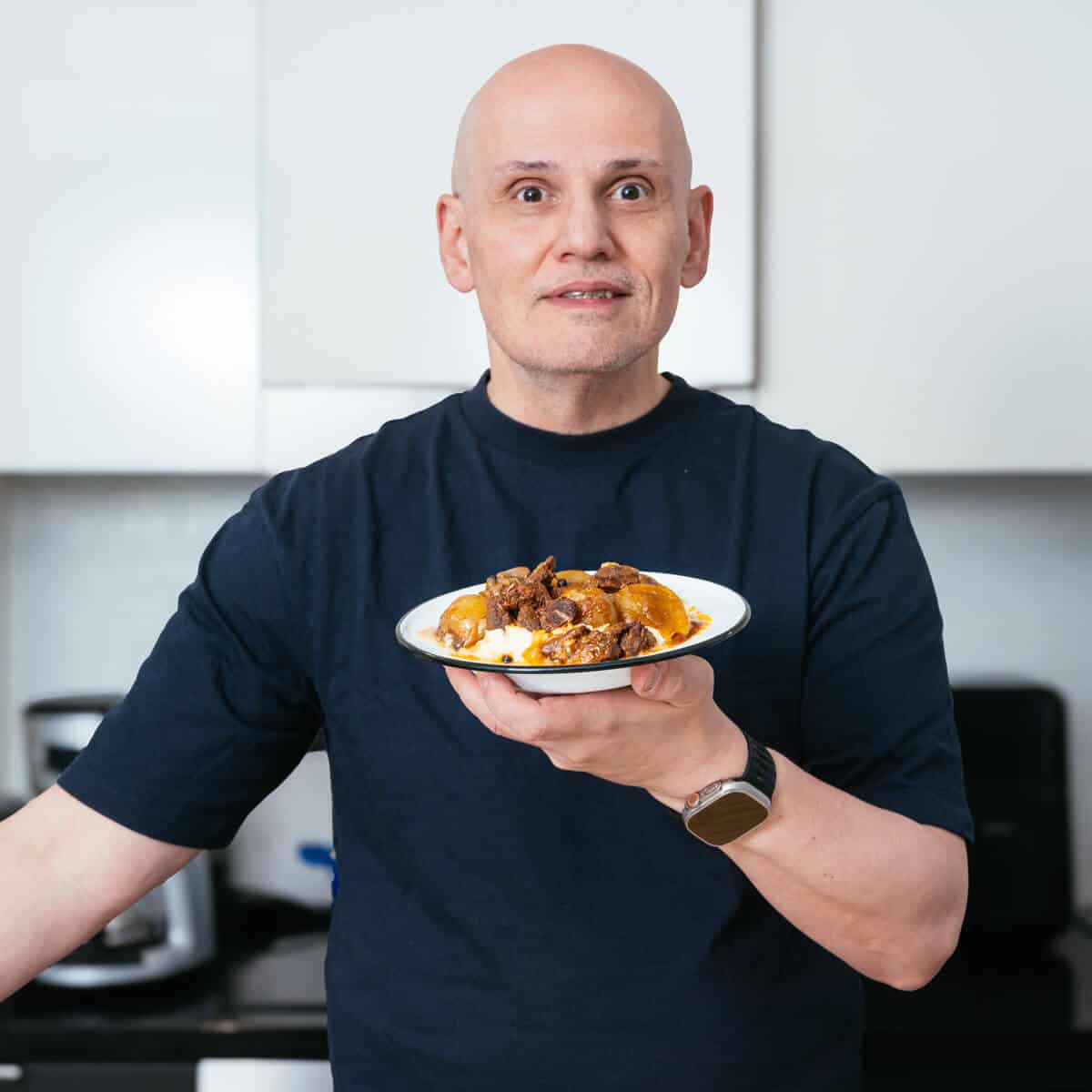 blogger -Peter G - holding his finished dish of beef stifado.