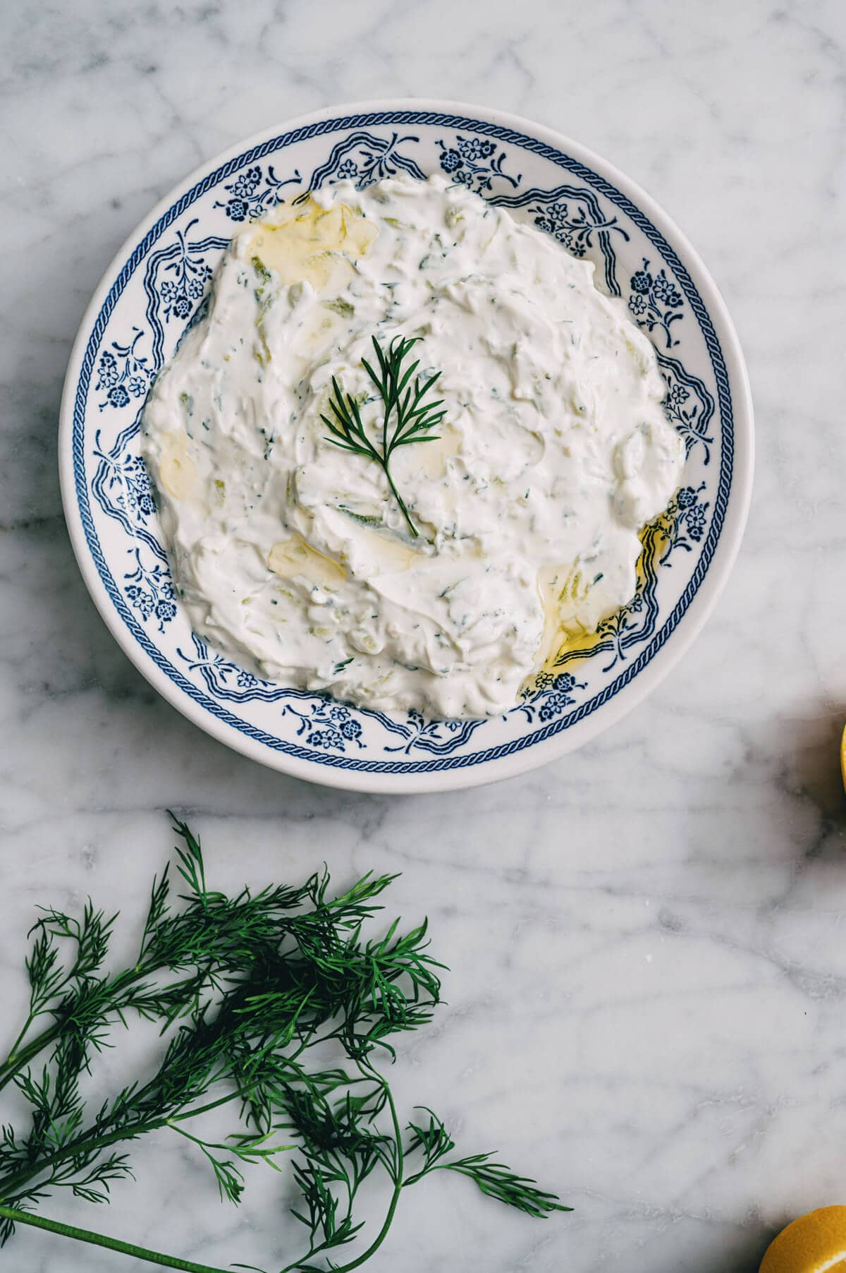 Greek tzatziki served in a patterned bowl with dill garnish.