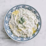 Close-up of creamy tzatziki topped with fresh dill.