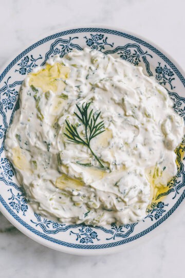 Close-up of creamy tzatziki topped with fresh dill.