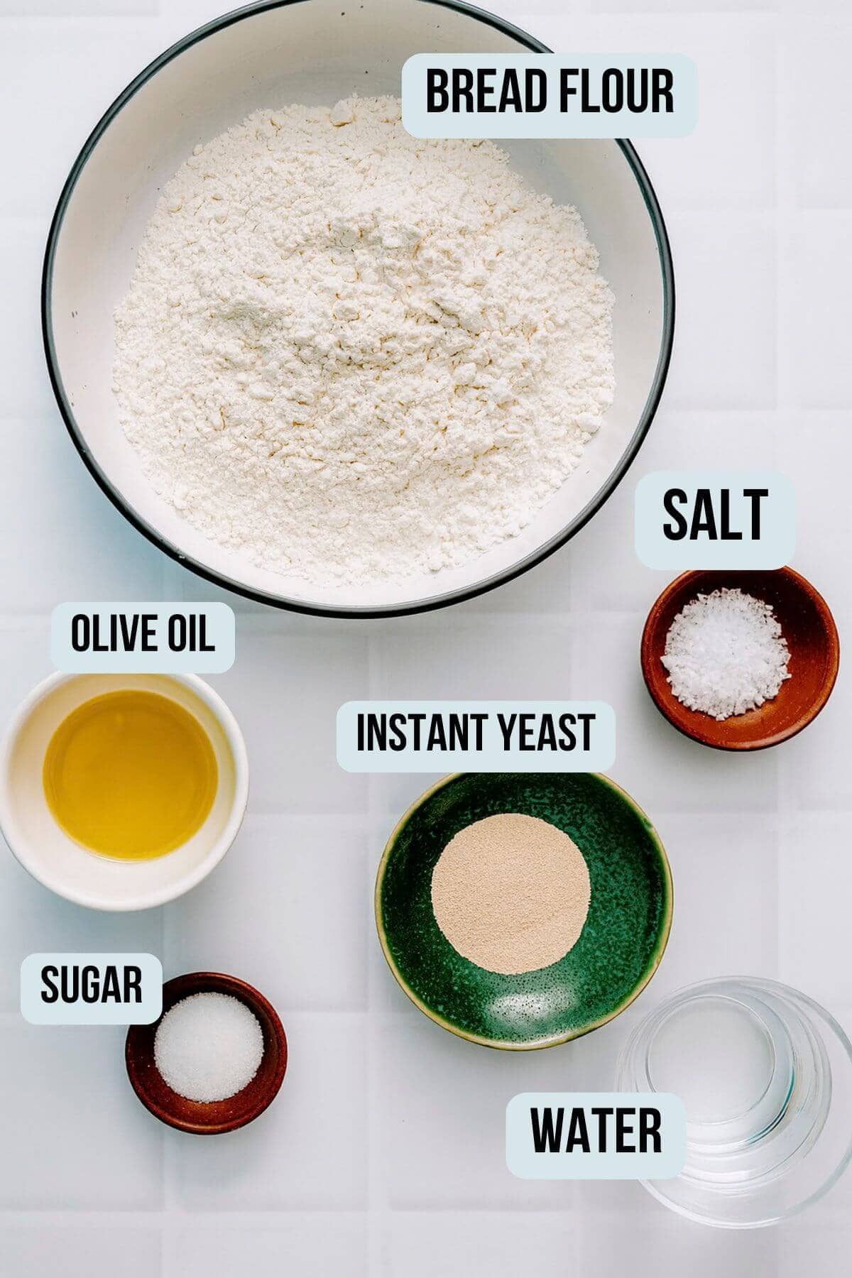 Ingredients for Greek pita bread including flour, yeast, olive oil, salt, sugar and water.