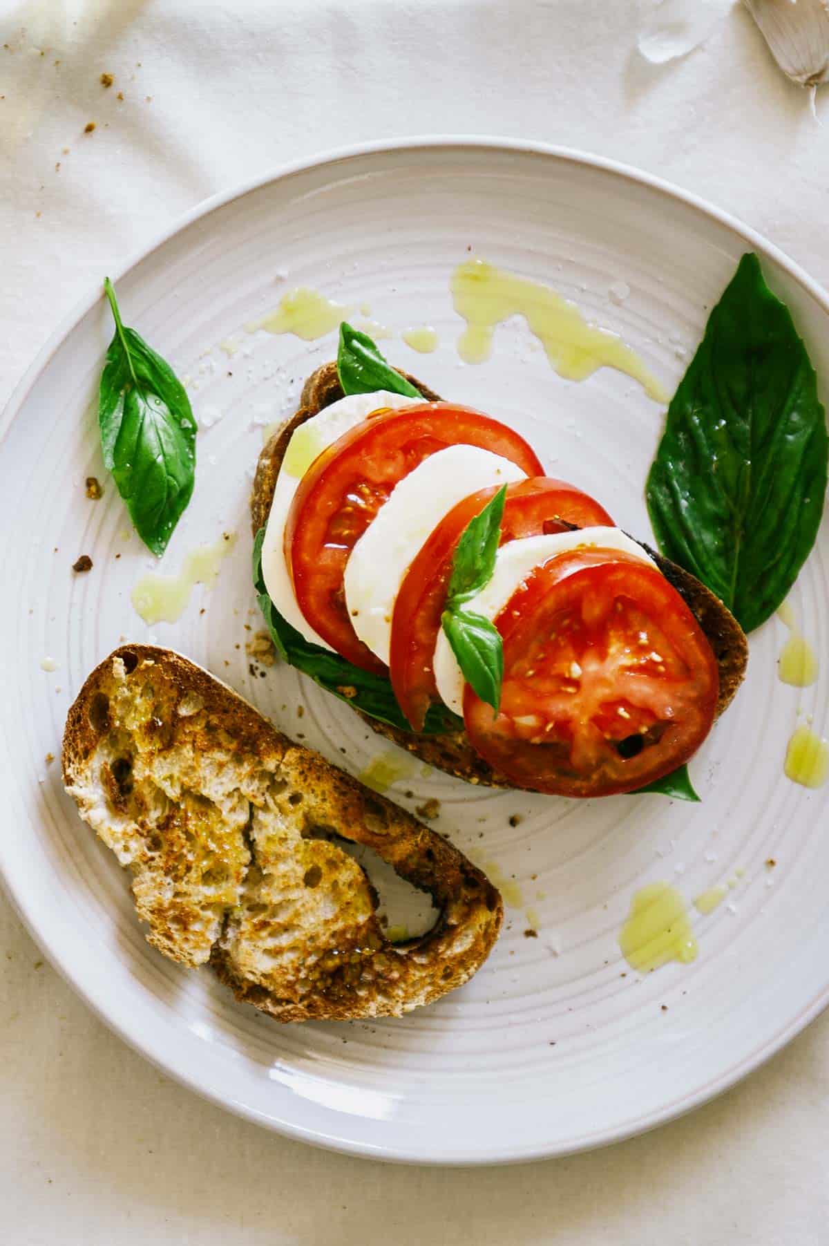 overhead view of caprese bruschetta with olive oil drizzle.