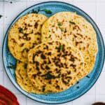 Overhead shot of homemade chickpea flatbread on a blue plate.