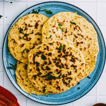 Overhead shot of homemade chickpea flatbread on a blue plate.