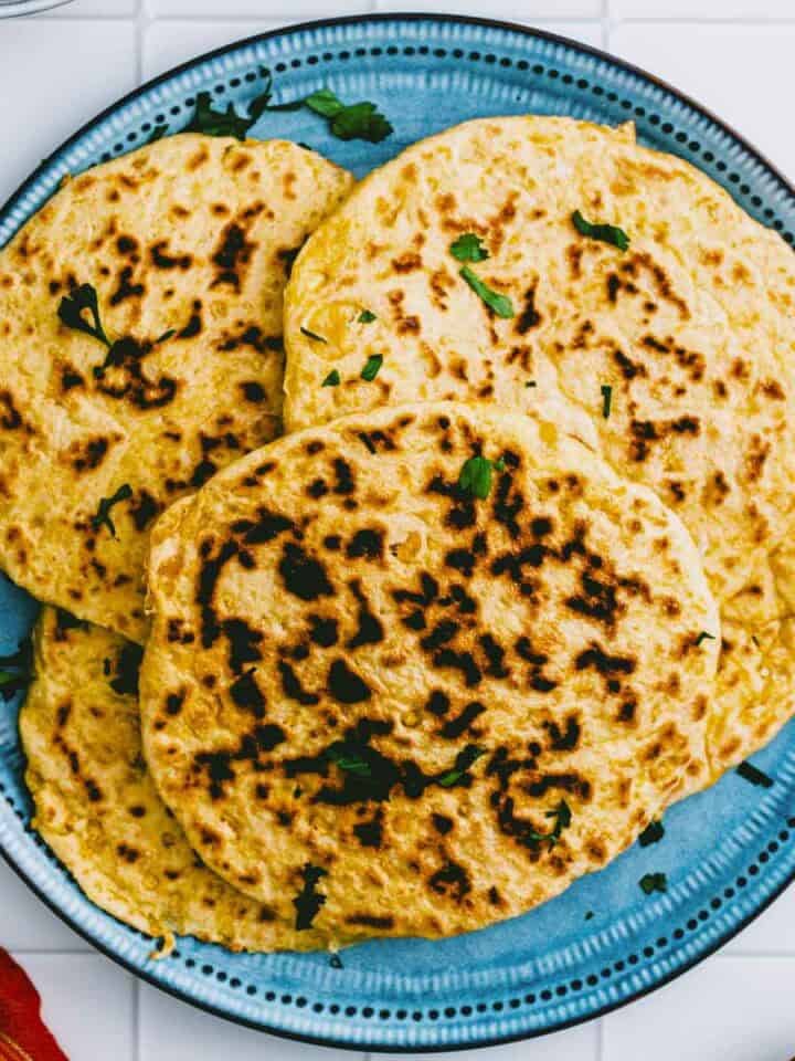 Overhead shot of homemade chickpea flatbread on a blue plate.
