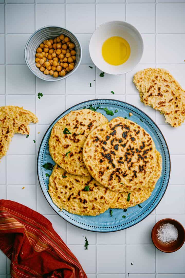 Chickpea flatbread served with olive oil and chickpeas.