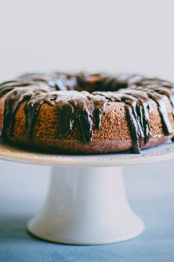 Chocolate beetroot cake on a cake stand with glossy dark chocolate ganache.