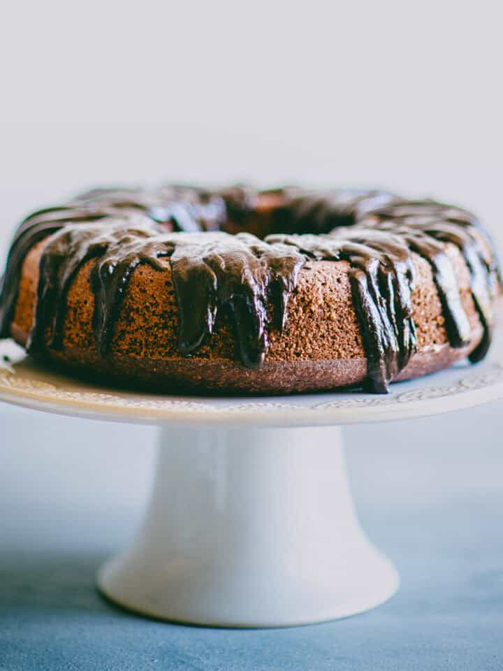 Chocolate beetroot cake on a cake stand with glossy dark chocolate ganache.