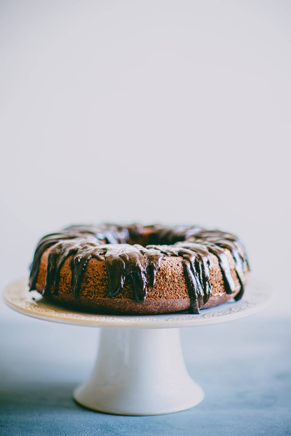 Chocolate beetroot cake on a cake stand with glossy dark chocolate ganache.