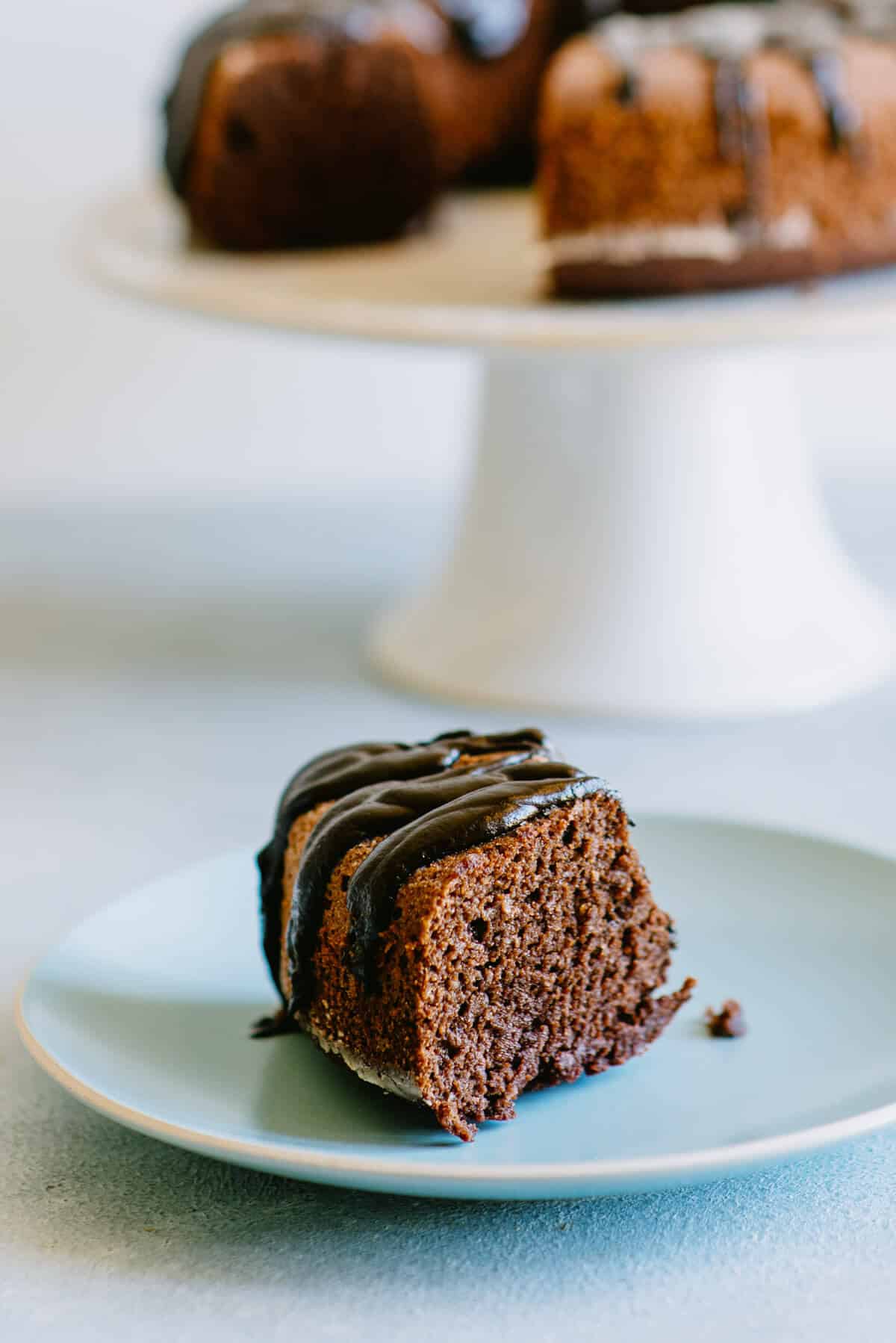 Close up of a slice of chocolate beetroot cake with ganache on a plate.