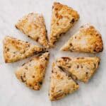 baked date scones cut into wedges arranged on marble surface.
