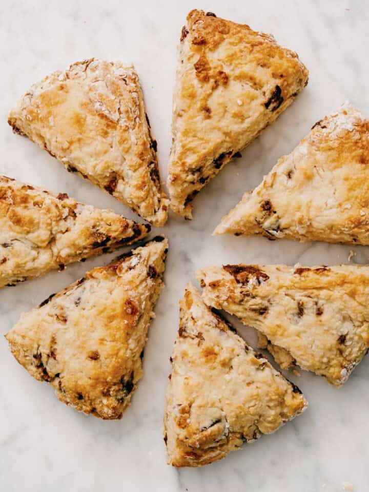 baked date scones cut into wedges arranged on marble surface.