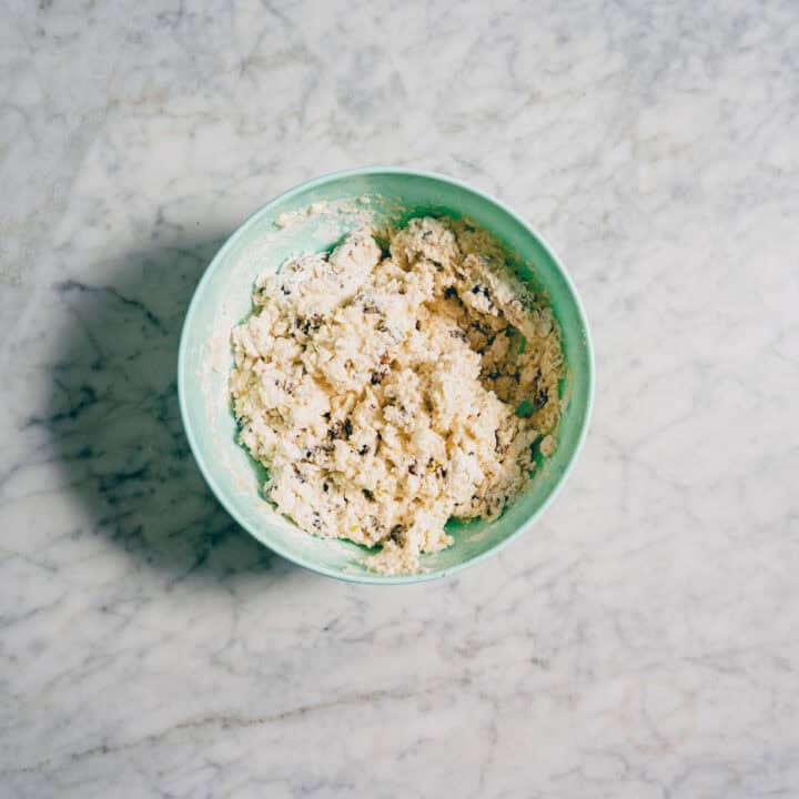 rough scone dough with dates mixed in bowl before shaping.