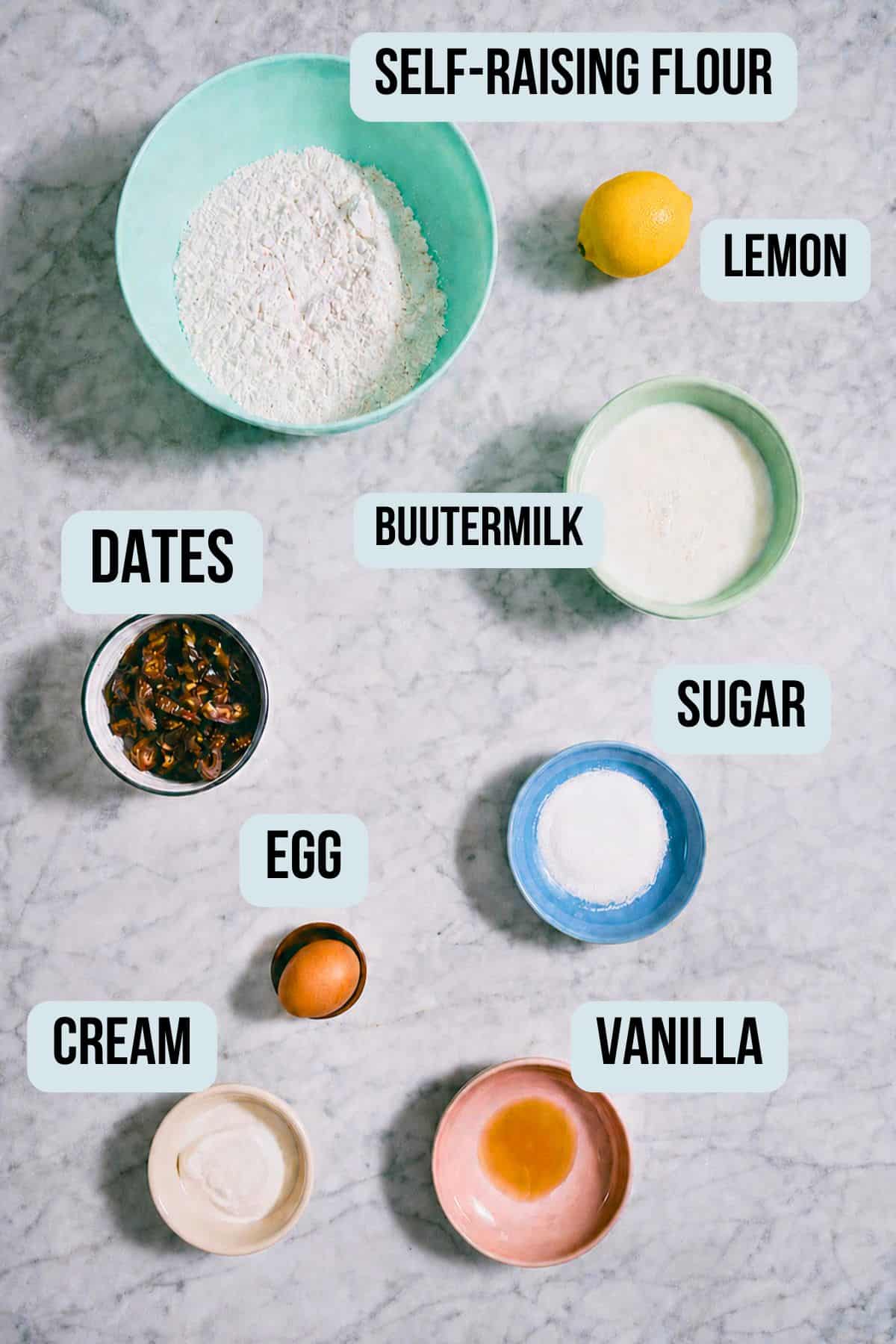labelled ingredients for date scones presented on a marble surface.